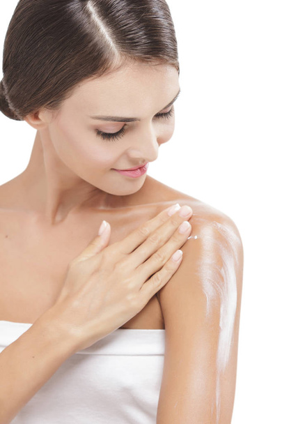 beautiful woman applying body lotion to her arms - Foto, Bild