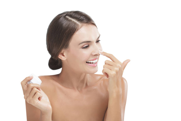 beautiful young woman smiling while take some facial cream - Foto, Bild