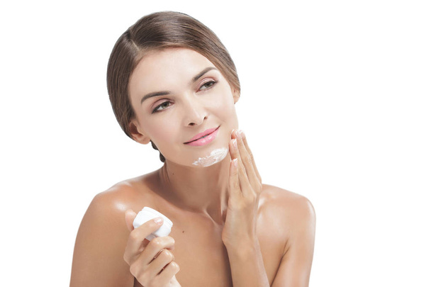 beautiful young woman applying some facial cream - Foto, Bild