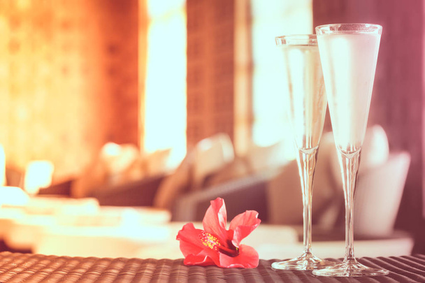 zwei Gläser Champagner mit roten Blüten in einer Wellness-Lounge. Wellnessbereich - Foto, Bild