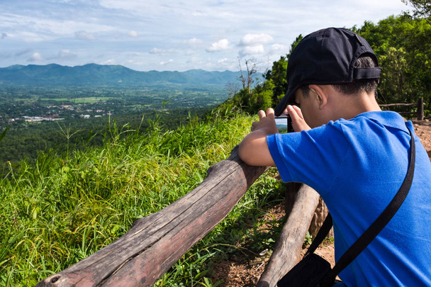 Boční pohled na asijské chlapce relaxaci na čerstvém vzduchu ve dne, cestování na dovolenou - Fotografie, Obrázek