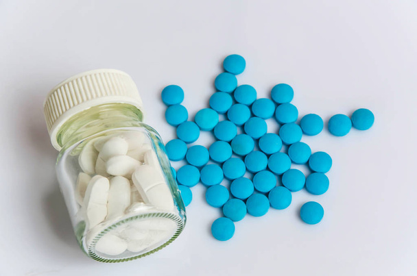 blauwe pillen geneeskunde & witte pillen geneeskunde in fles  - Foto, afbeelding
