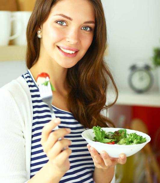 Junge Frau isst Salat und hält eine gemischte - Foto, Bild