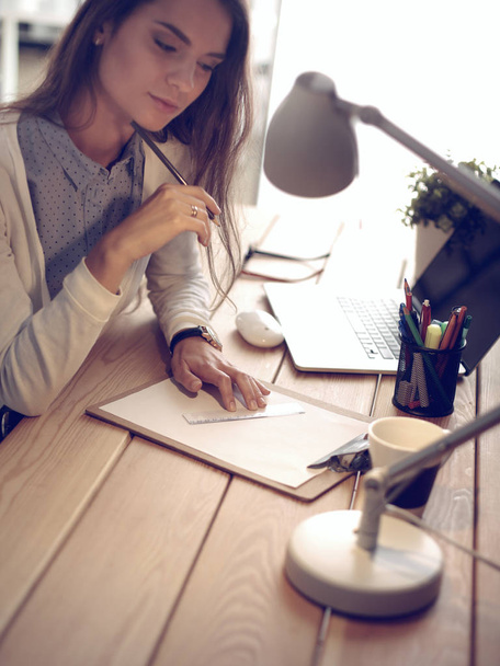 Young female working sitting at a desk - Φωτογραφία, εικόνα