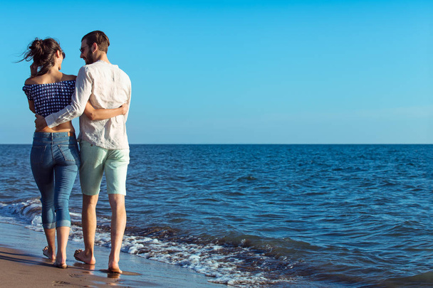 Счастливая межрасовая пара, гуляющая по пляжу
. - Фото, изображение