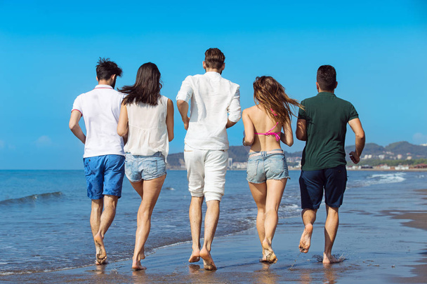 Group of young people running on beach - Foto, Imagen