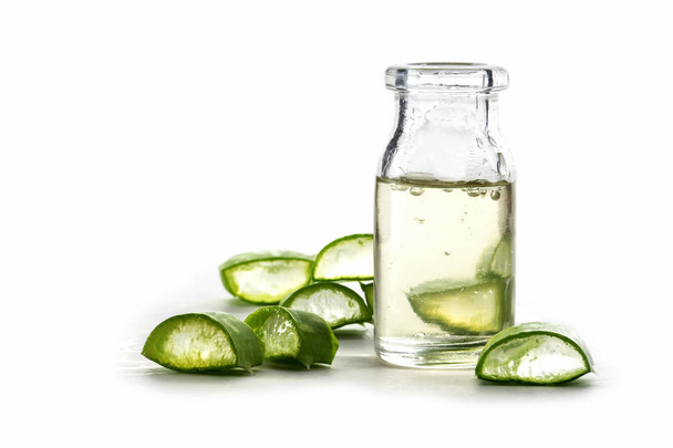 Slices of fresh aloe vera leaf and a bottle with the transparent gel, used for medicinal purposes, isolated on white - Zdjęcie, obraz