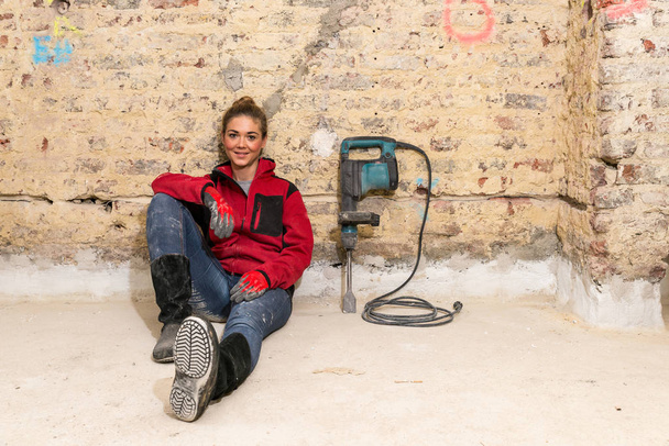 Ambiciózní craftswoman sedí na podlaze před cihlovou zeď v - Fotografie, Obrázek