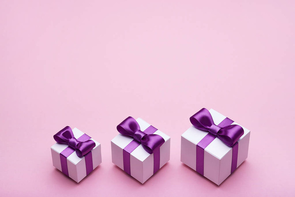 schöne Geschenke mit Satinschleifen auf rosa Hintergrund - Foto, Bild