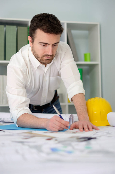 Architect bezig met zijn projecten papers in het kantoor - Foto, afbeelding
