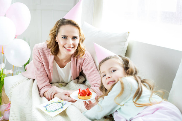 Mother and daughter with strawberry cake  - Фото, зображення