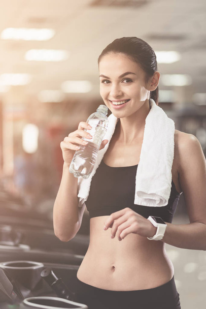 Joyful woman drinking water after sport exercises - Fotó, kép