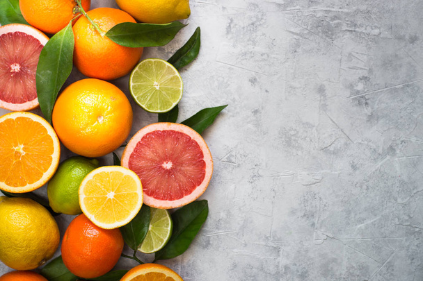 Citrus fruit on grey concrete table.  - Foto, afbeelding