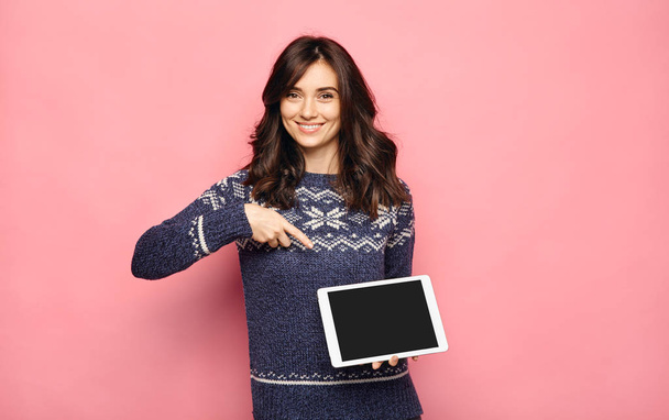 Femme en pull Holding tablette avec écran vierge
 - Photo, image