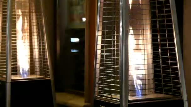 Dwa nowoczesne Torcheres z połyskujących płomień w nich stoi w Windowshop - Materiał filmowy, wideo