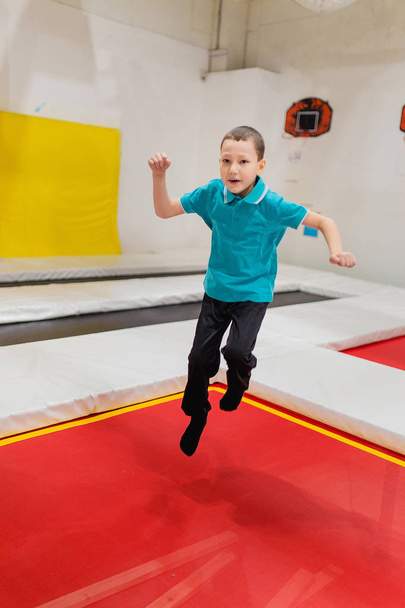 Lapsi poika hyppää trampoliini lentää puistossa
 - Valokuva, kuva