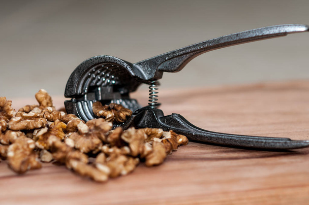 tongs for chopping walnuts and shelled walnut - Fotografie, Obrázek