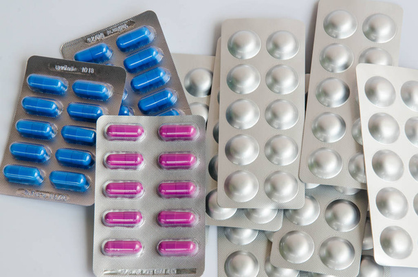 píldoras azul / púrpura medicina en blister sobre fondo blanco y blister de Alu-Alu
 - Foto, Imagen