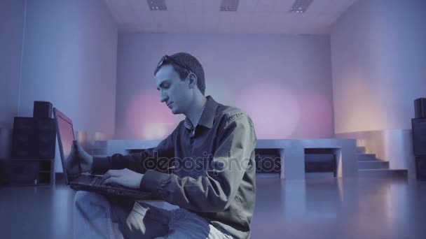 Man using a laptop being alone on the dance floor - Filmagem, Vídeo