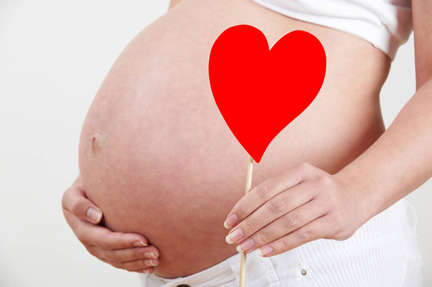Close Up Of Pregnant Woman Holding Heart Shape On Stick - Fotoğraf, Görsel