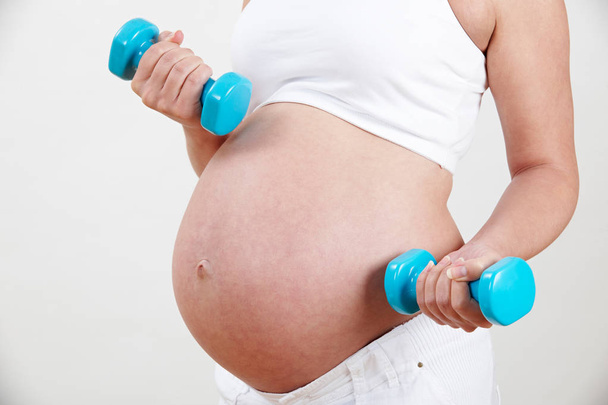 Close Up Of Pregnant Woman Exercising With Weights - Фото, зображення