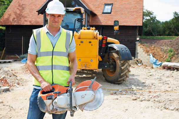 Construction Worker On Site Holding Circular Saw - Fotoğraf, Görsel