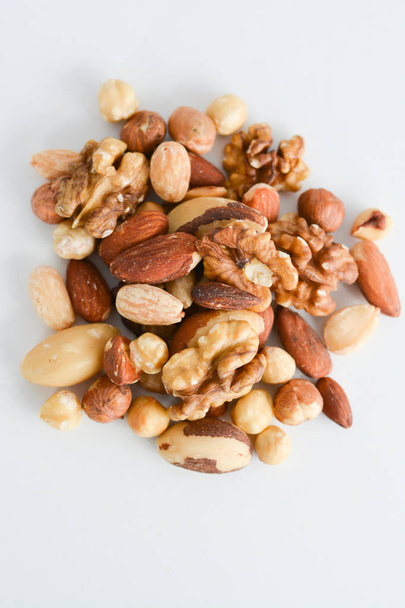 Různé druhy ořechů smíšené a izolované na bílém pozadí - Fotografie, Obrázek