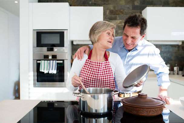 Senior couple in the kitchen cooking together. - Valokuva, kuva
