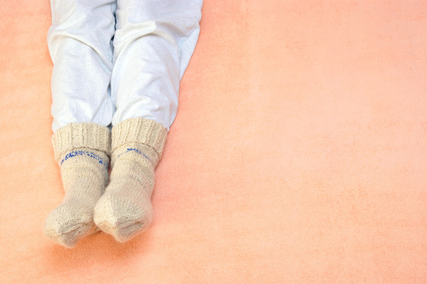 Woman's feet warming at a bed - Zdjęcie, obraz