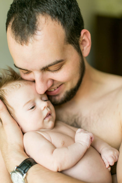 Papa umarmt sein Neugeborenes. Vaterliebe. Nahaufnahme Porträt eines Mannes und seiner kleinen Tochter - Foto, Bild