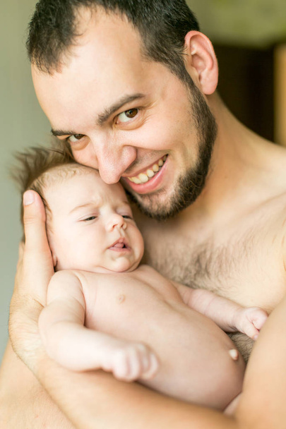 Папа обнимает своего новорожденного ребенка. Отцовская любовь. Портрет крупным планом человека и его маленькой дочери
 - Фото, изображение