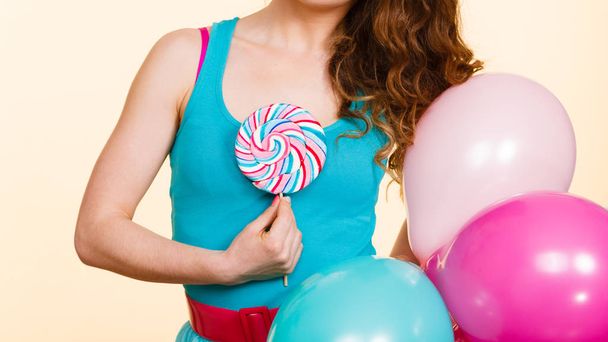 Woman holds colorful balloons and lollipop - Fotó, kép