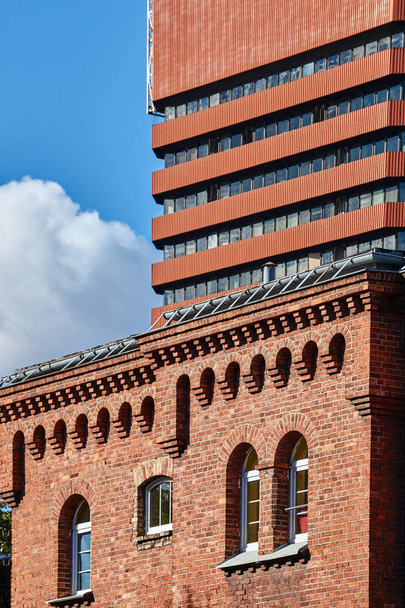 Le bâtiment historique en brique rouge et le gratte-ciel moderne
 - Photo, image