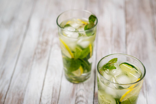 Water with lemon, mint and cucumber on wooden light background. Water Detox. - Foto, Imagen