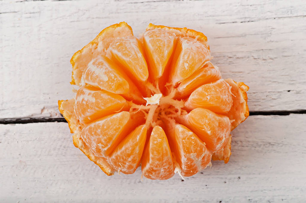 Tangerine slices on a wooden background, fruit. - Φωτογραφία, εικόνα