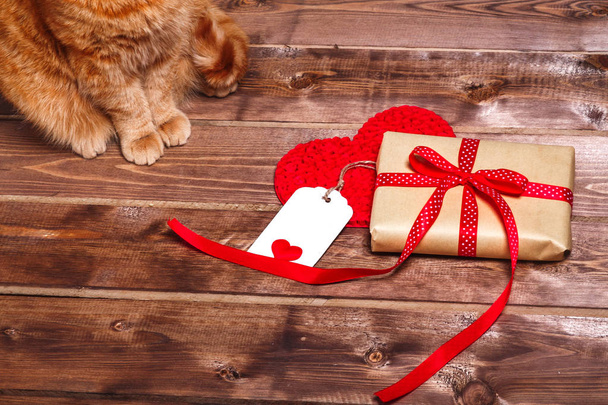 Wrapped vintage gift box with red ribbon bow and gift card  on wooden background  - Foto, Bild