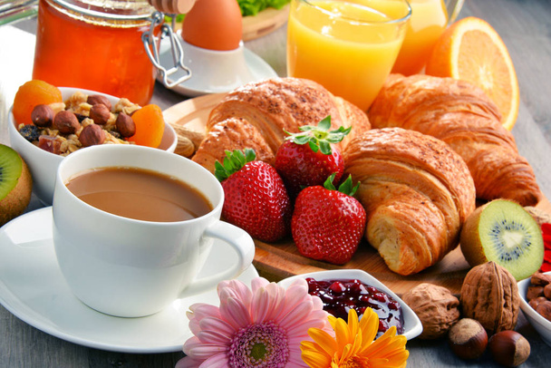 Breakfast consisting of croissants, coffee, fruits, orange juice - Photo, Image