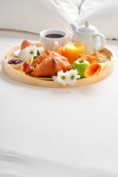 Dienblad van het ontbijt in bed in hotelkamer - Foto, afbeelding