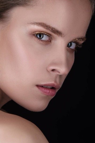 Close-up portrait of beautiful young woman. Fashion shiny highlighter, sexy gloss lips. Healthy skin and dark eyebrows. - Photo, Image