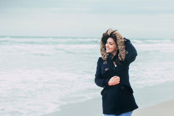 Rüzgarlı hava gülümsüyor denizde arka plan üzerinde kız - Fotoğraf, Görsel