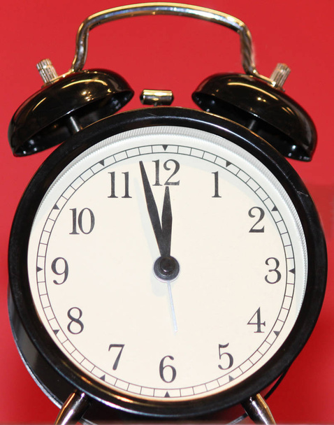 Ретро чорний будильник з червоним фоном - Фото, зображення