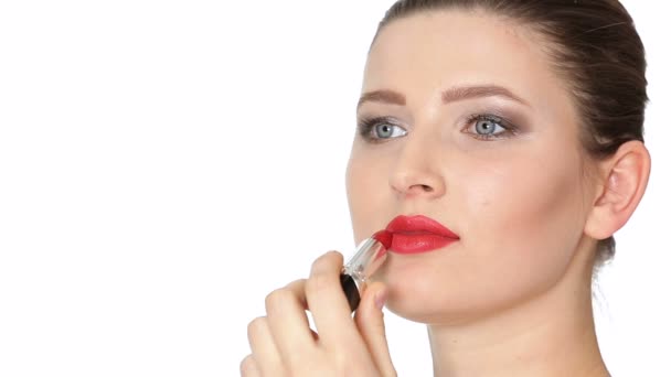 Frau trägt roten Lippenstift auf Lippen auf weißem Hintergrund auf. - Filmmaterial, Video