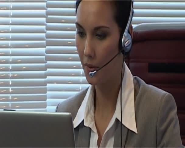 Businesswoman with headset is talking using IP telephony - Πλάνα, βίντεο