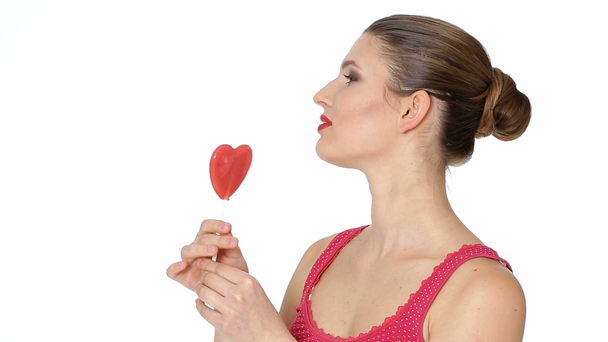Жінка тримає льодяник у формі серця. День Святого Валентина - Кадри, відео
