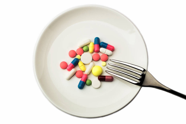 Pills on white plate with fork. Pill instead of food - Foto, imagen