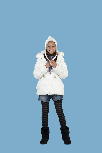 Happy girl with winter hat , on blue - Foto, afbeelding