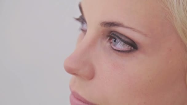 Κοντινό πλάνο. Make-up artist εφαρμογή eyeliner γύρω από το ολόκληρο μάτι του μοντέλου - Πλάνα, βίντεο