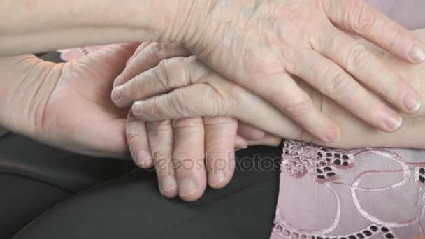 Mujer sosteniendo flácidas manos arrugadas de anciana
 - Imágenes, Vídeo