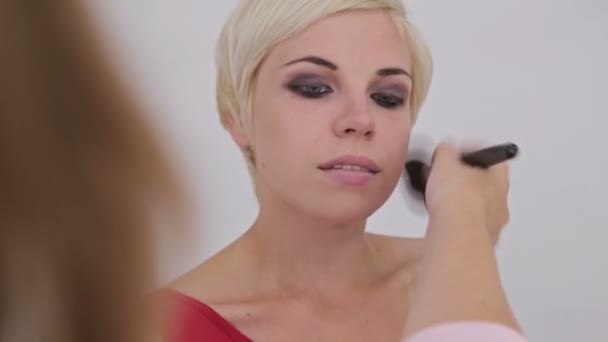 Profesionální vizážistka použití prášku na žena s tváří - Záběry, video