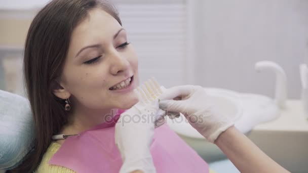 Dentist makes procedures and treat teeth for a beautiful patient woman in dental clinic. Concept of healthy life. Close up scene - Кадри, відео